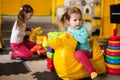 Baby girl swings on yellow paralon duck at kindergarten Royalty Free Stock Photo