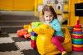 Baby girl swings on yellow paralon duck at kindergarten Royalty Free Stock Photo