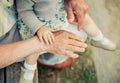 Baby girl touching hand of senior man