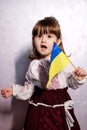 Baby Girl Ukrainian in embroidery dress protesting war conflict raises national flag Royalty Free Stock Photo