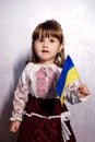 Baby Girl Ukrainian in embroidery dress protesting war conflict raises national flag Royalty Free Stock Photo