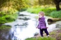 Baby girl walking on a river shore on autumn day Royalty Free Stock Photo