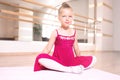 Baby girl wearing a peach tutu. a smiling baby girl is Sitting and stretching out on a sports mat Royalty Free Stock Photo