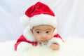 Baby girl wearing red Santa Claus costume sit on white fur carpet. Concept of celebrates Christmas and New Year Royalty Free Stock Photo