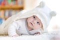 Baby girl wearing white towel or winter overal in white sunny bedroom Royalty Free Stock Photo