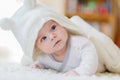 Baby girl wearing white towel or winter overal in white sunny bedroom Royalty Free Stock Photo