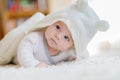 Baby girl wearing white towel or winter overal in white sunny bedroom Royalty Free Stock Photo