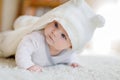 Baby girl wearing white towel or winter overal in white sunny bedroom Royalty Free Stock Photo