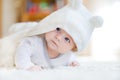 Baby girl wearing white towel or winter overal in white sunny bedroom Royalty Free Stock Photo