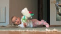 A baby girl in pink tights lying on a floor with toy sheep Royalty Free Stock Photo