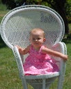 Baby girl in wicker chair Royalty Free Stock Photo