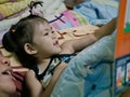 A baby girl, 2 years old, enjoys reading a story or book together with her mother Royalty Free Stock Photo