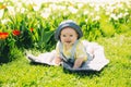 Baby in green grass of tulip field at springtime Royalty Free Stock Photo