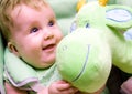 Baby with green soft toy