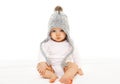 Baby in grey knitted hat on white background