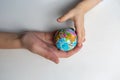 Baby and hand of adult man holding a small globe during the epidemic Royalty Free Stock Photo