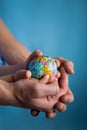 Baby and hand of adult man holding a small globe during the epidemic Royalty Free Stock Photo