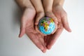 Baby and hand of adult man holding a small globe during the epidemic Royalty Free Stock Photo