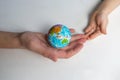 Baby and hand of adult man holding a small globe during the epidemic Royalty Free Stock Photo