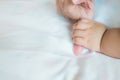 Baby hand on the bed, soft focus newborn tiny hand, Children hand gently holding mother of love with family.