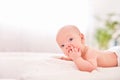 A baby with a hand in his mouth. teething in children. sucking reflex. hungry little baby. lying on his stomach on their own holds Royalty Free Stock Photo