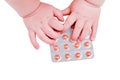 Baby hand and medicines tablets in a package, close-up, isolated on a Royalty Free Stock Photo