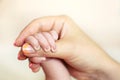 Baby hand in mom's hand with a blurred background