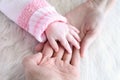 Baby hand into parents hands, close up