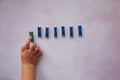 Baby hand picks one stationery clothespins. Curiosity and be different concept. Copy space