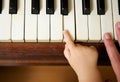 Baby hand playing piano with adult hand Royalty Free Stock Photo