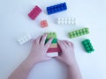 Baby hands playing with plastic blocks on white background Royalty Free Stock Photo