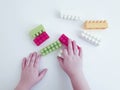 Baby hands playing with plasticconstruction blocks on white background Royalty Free Stock Photo