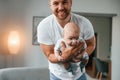 With baby in hands. Smiling, having fun. Father with toddler is at home, taking care of his son Royalty Free Stock Photo