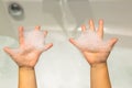 Baby hands with soap suds. Small child in the bathroom Royalty Free Stock Photo