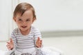 Baby, happy and playing on floor, child development and infant growth with face, sitting and home. Girl, joyful and Royalty Free Stock Photo