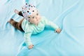 Baby in hat crawling on the blue coverlet Royalty Free Stock Photo