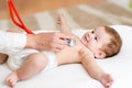 Baby having it's heartbeat checked by doctor