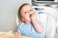 Baby in highchair covered in fruit, vegetable puree close-up. Complementary feeding tredhead oddler concept