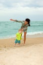 Baby and his mother walking on the beach