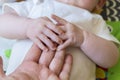 Baby holding adult parent`s hand