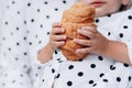 The baby holds a croissant in his hand. holding delicious croissant with golden crust Royalty Free Stock Photo