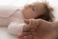 Baby holds fathers thumb in hand during carefree healthy sleep Royalty Free Stock Photo