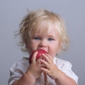 Baby holds a red apple eating