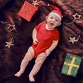 Baby infant boy in a Christmas Santa hat on a brown fur coat with boxe Royalty Free Stock Photo