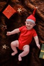 Baby infant boy in a Christmas Santa hat on a brown fur coat with boxe Royalty Free Stock Photo