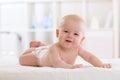 Baby infant boy wearing diaper lying in bed in white light bedroom or nursery. Textile and bedding for children. Royalty Free Stock Photo