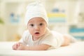 Baby lying on soft bed cover with cap Royalty Free Stock Photo