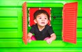 Baby inside toy house playhouse child look out the window Royalty Free Stock Photo