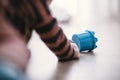 Baby kid playing with a blue plastic cilinder on a hardwood floor Royalty Free Stock Photo