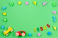 Baby kid toy background. Colorful wooden cubes, cars and numbers on green background